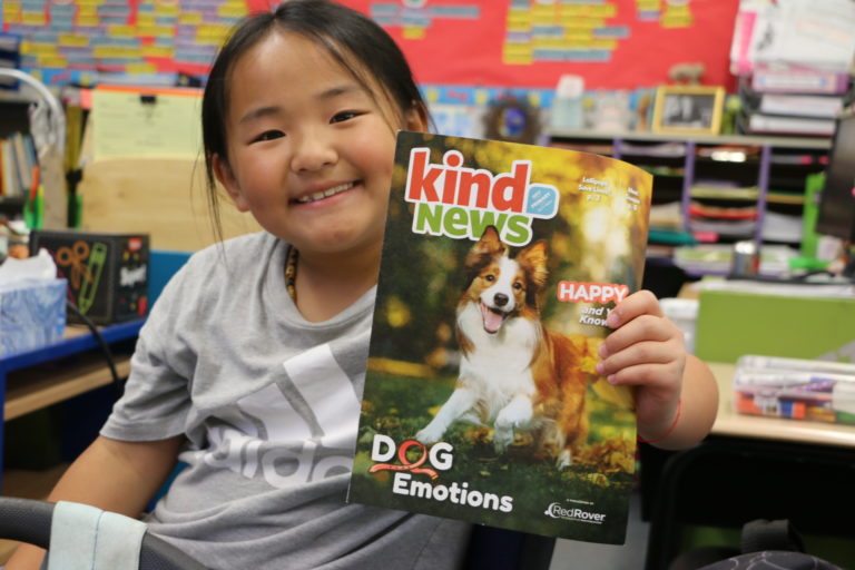 Kind News magazine - girl hoding magazine